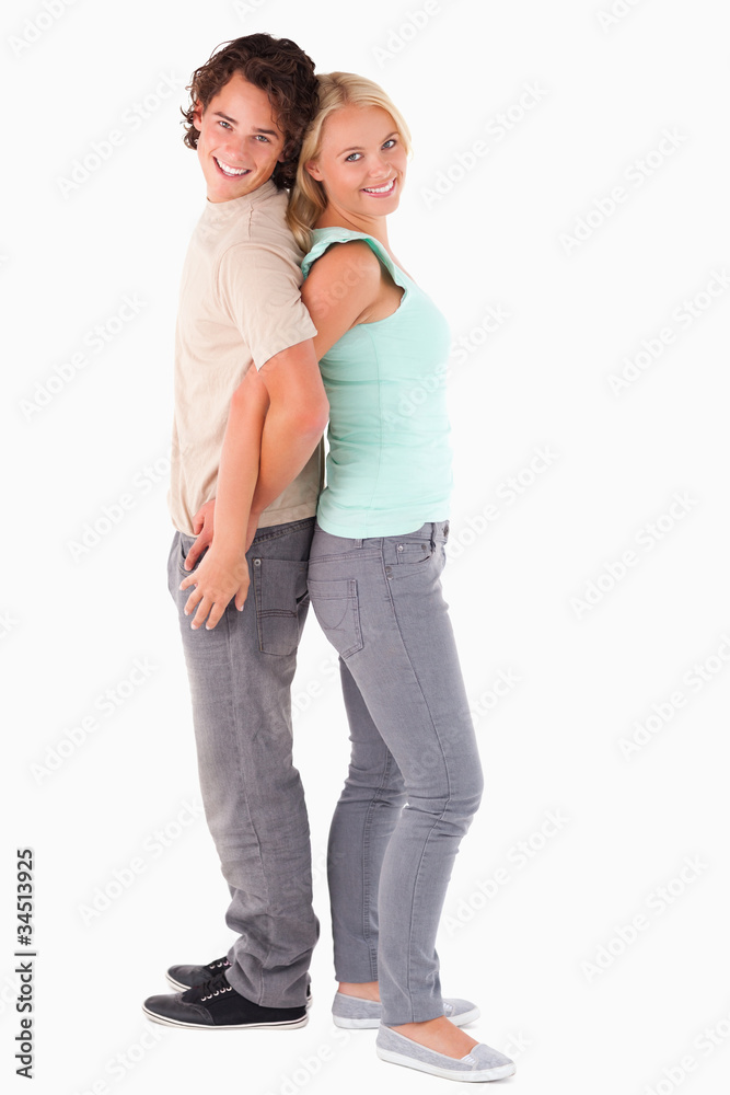 Happy couple standing back to back Happy couple standing back to back