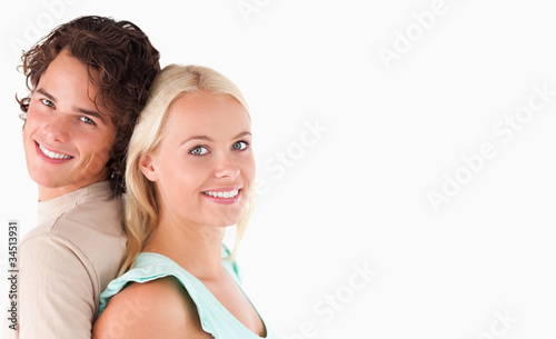 Portrait of a joyful couple standing back to back