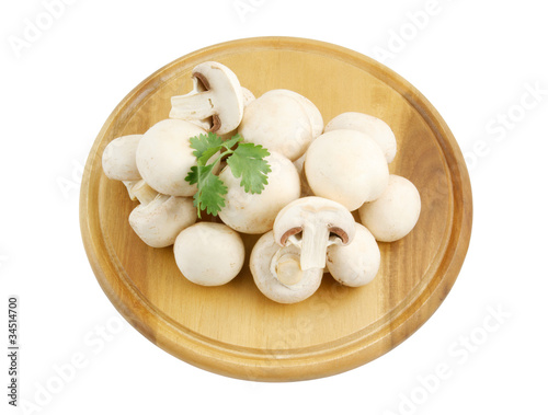 Fresh mushrooms and parsley on wooden cutting board isolated