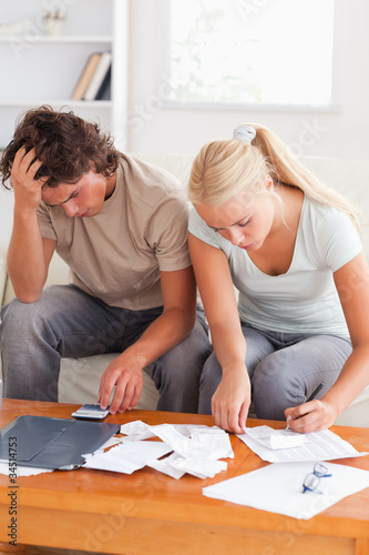 Despaired couple calculating their expenses