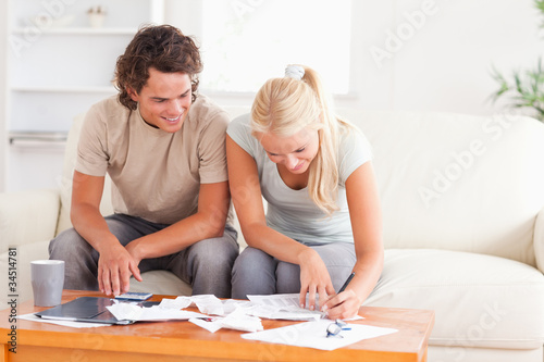 Smiling couple calculating their expenses
