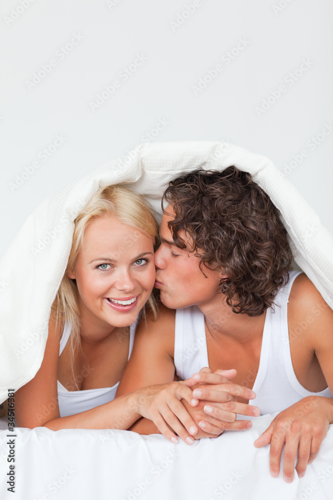 Portrait of a man kissing his girlfriend on the cheek Portrait of a man kissing his girlfriend on the cheek