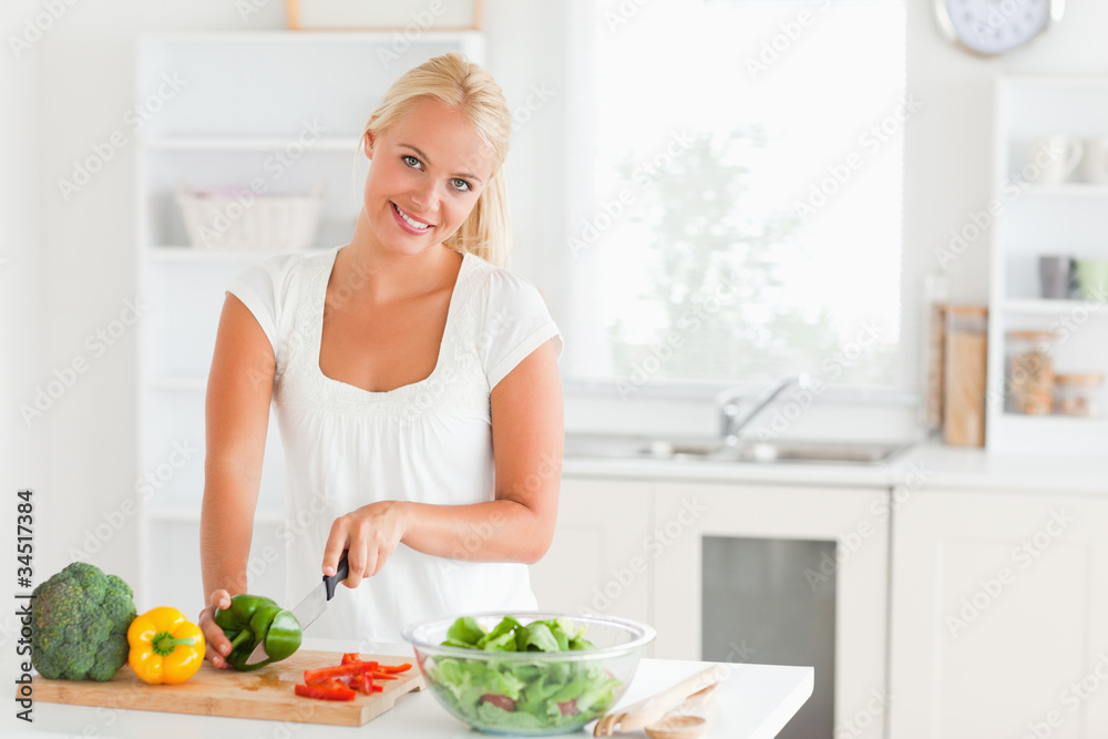 Good looking woman slicing pepper