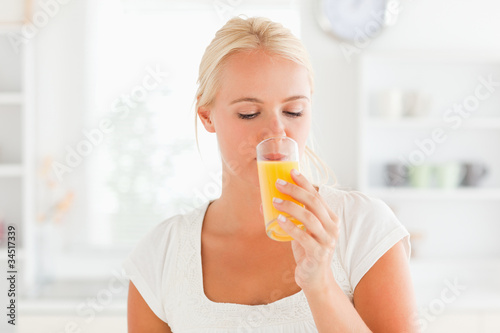 Blonde woman drinking orange juice