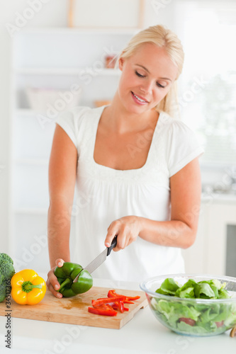Blonde woman slicing pepper