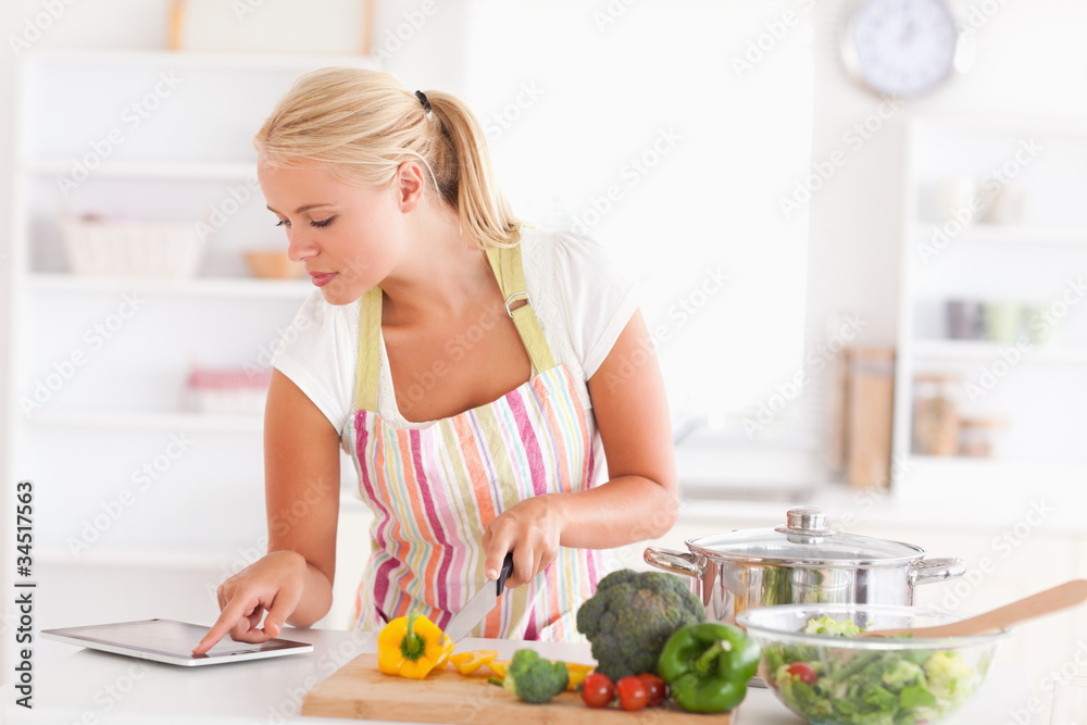 Blonde woman using a tablet computer to cook Blonde woman using a tablet computer to cook