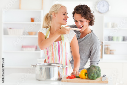 Woman making her fiance tasting her meal