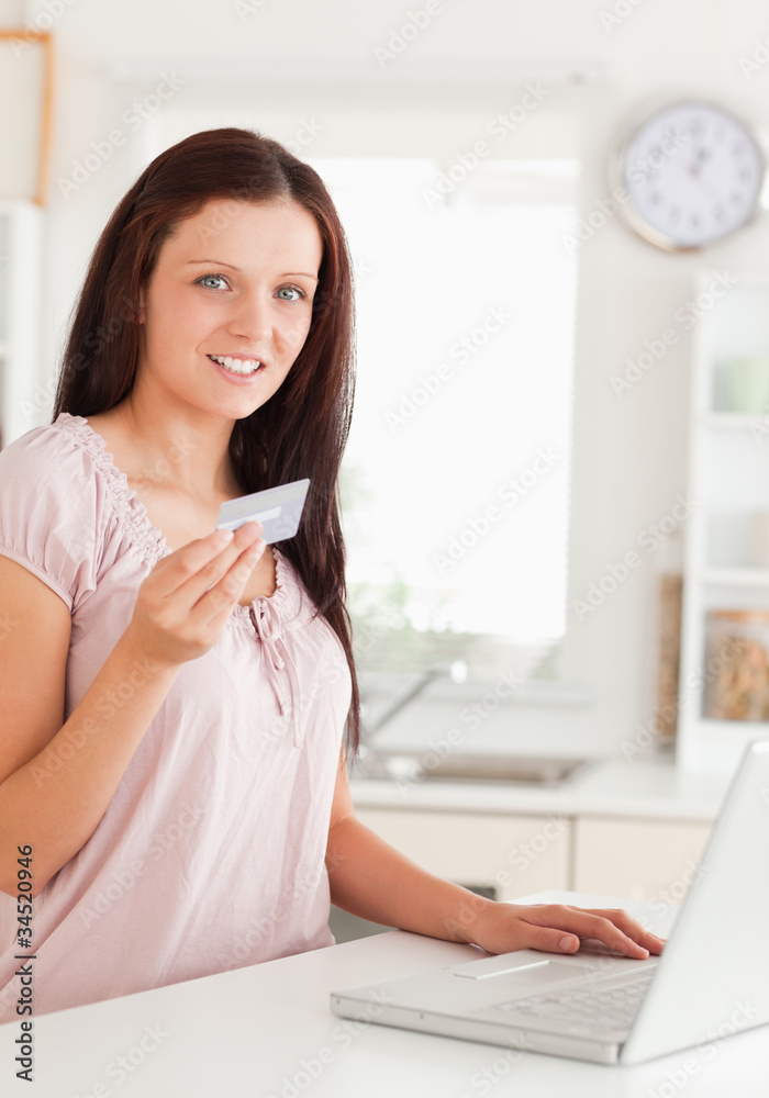 Woman showing credit card by notebook Woman showing credit card by notebook