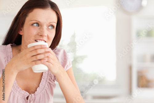 Woman with cup of coffe looking away