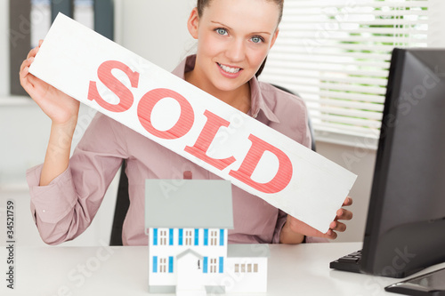 Businesswoman showing sold sign photo