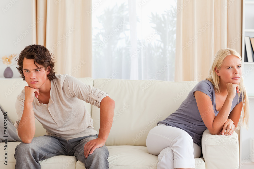 Upset couple sitting on a couch Upset couple sitting on a couch
