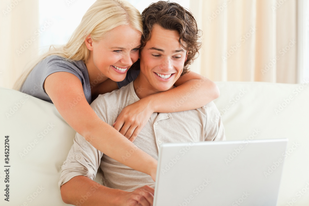 Smiling couple using a laptop Smiling couple using a laptop