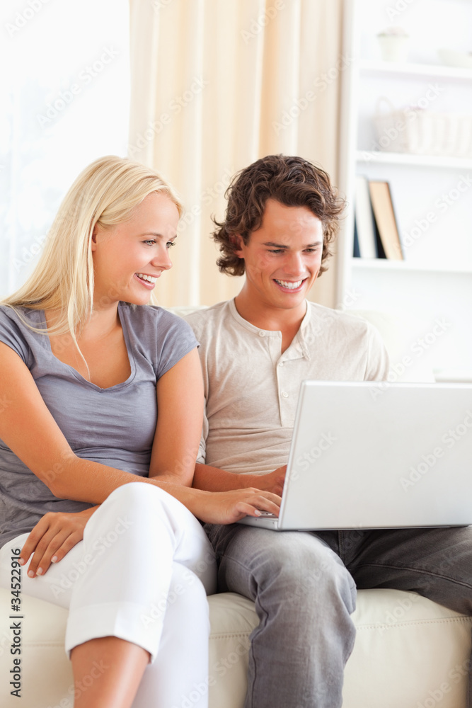 Portrait of a cute happy couple using a notebook Portrait of a cute happy couple using a notebook