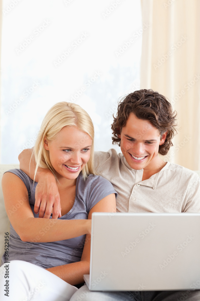 Portrait of a smiling young couple using a laptop Portrait of a smiling young couple using a laptop