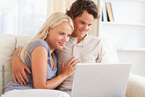 Lovely young couple using a notebook