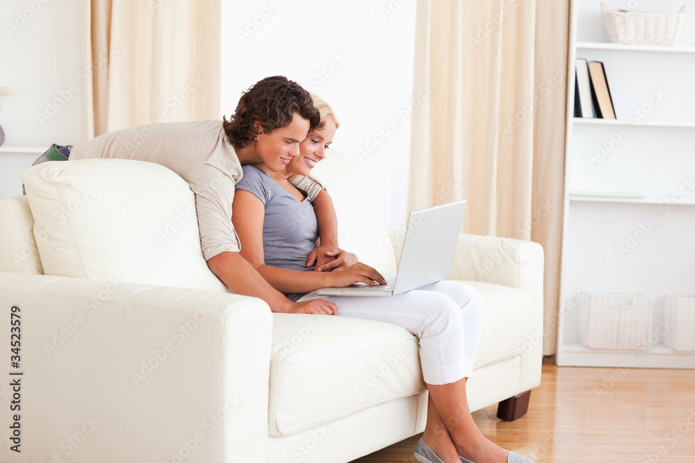 Smiling young couple using a notebook Smiling young couple using a notebook