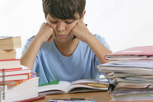 Jeune garçon penché sur ses devoirs photo