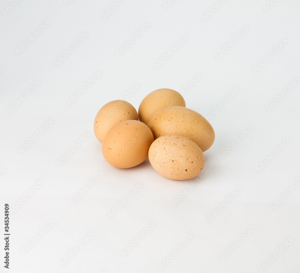 Five speckled brown eggs on white