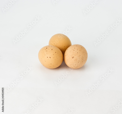 Photos Three spekled brown eggs on white