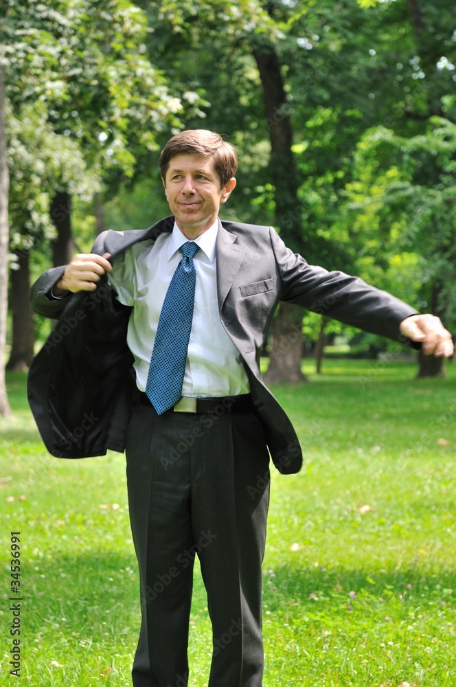 Senior business man putting on jacket Senior business man putting on jacket