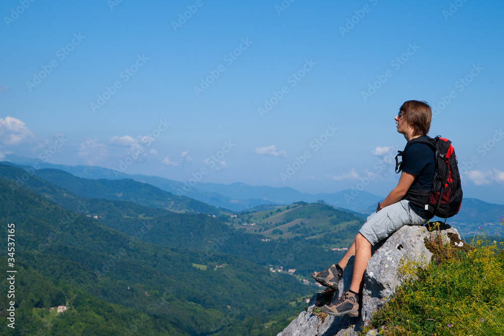 Fototapeta premium Jeune homme assis sur un rocher