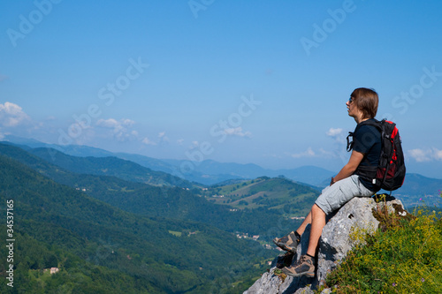 Jeune homme assis sur un rocher