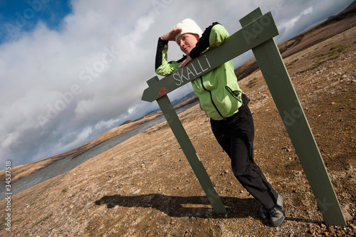 girl standing by the sign at Landmannalaugar, Iceland photo