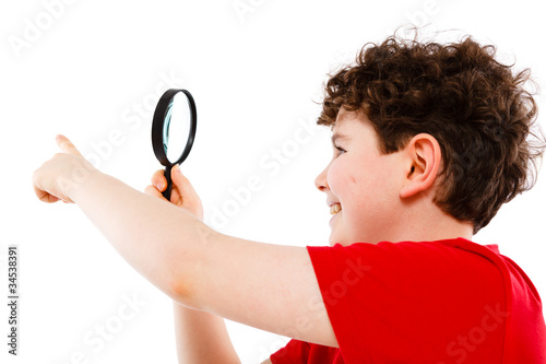 Boy looking through magnifying glass isolated on white