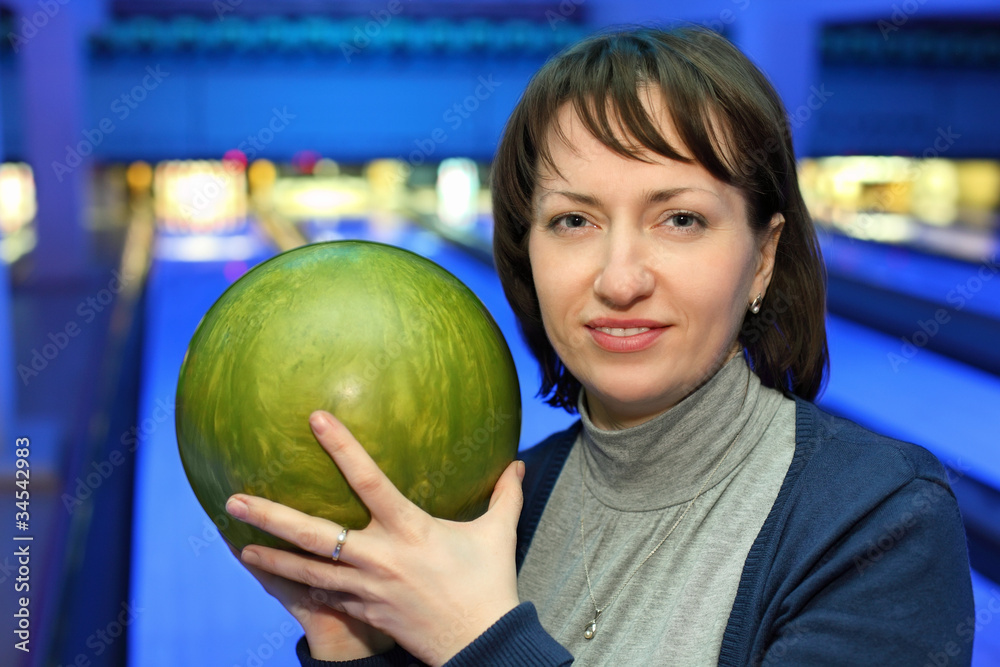Fototapeta premium Portrait of woman with green ball for bowling