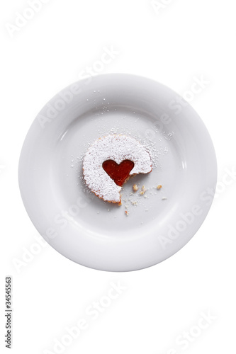 Pastry with a jam heart on a plate isolated on white