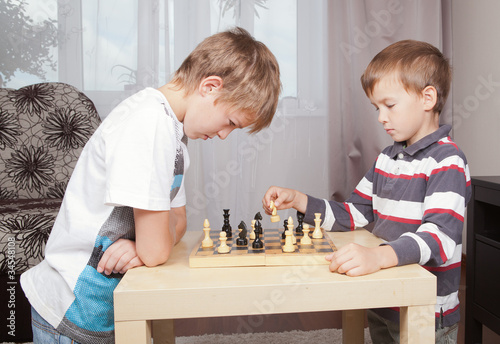 Two boys playing chess at home