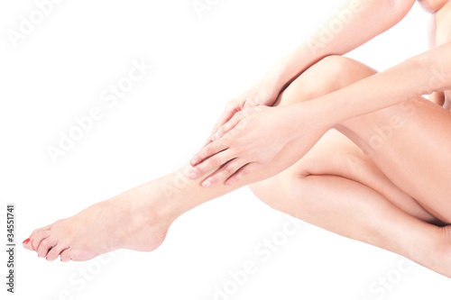 Woman massaging legs sitting on white background © A.Pavlov