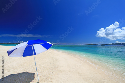 水納島の真っ白な砂の上に立つビーチパラソル