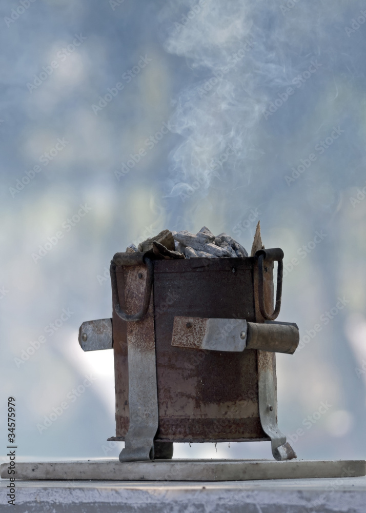 One mini stove with smoking wood chips as seen in India.