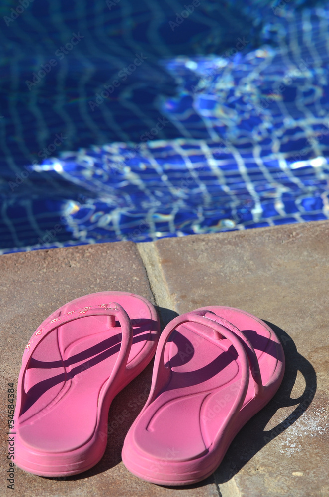 Naklejka premium Zapatillas en el borde de una piscina