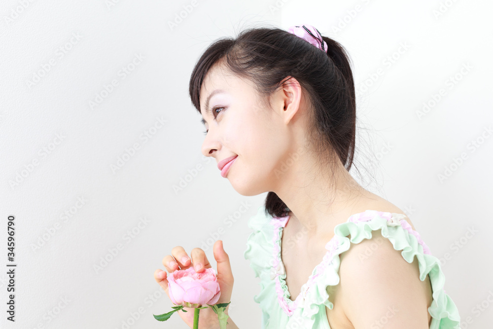 Fototapeta premium バラの花を持った若い女性