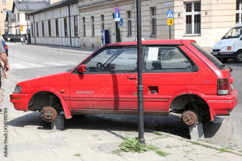 Red Car, parked with no wheels photo