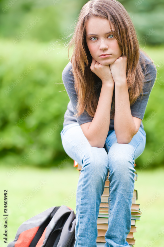 sad student girl sitting on books sad student girl sitting on books