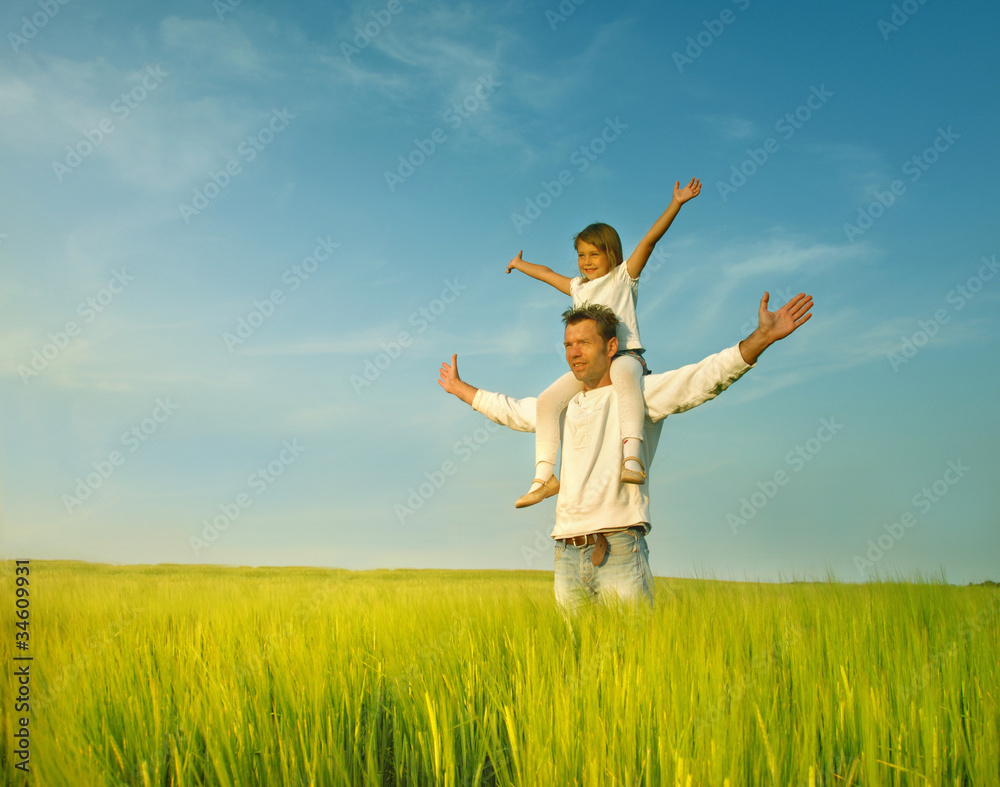 Father gives her daughter piggyback at sunset Father gives her daughter piggyback at sunset