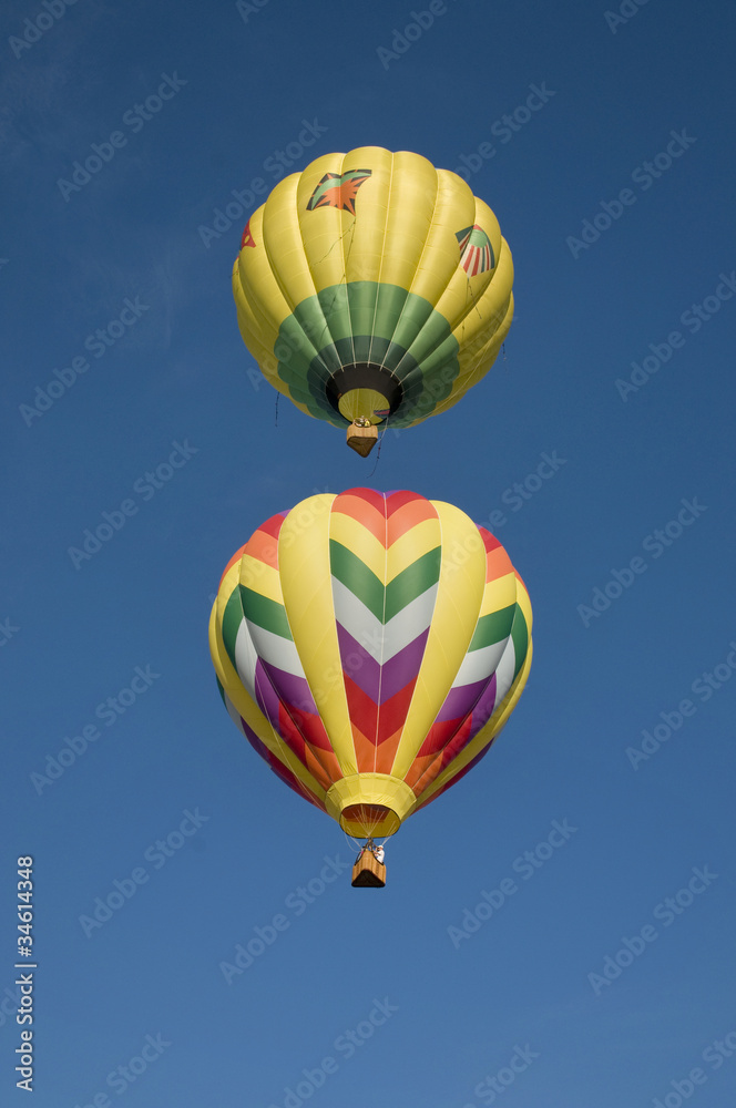 Two hot-air balloons flying vertically aligned Two hot-air balloons flying vertically aligned