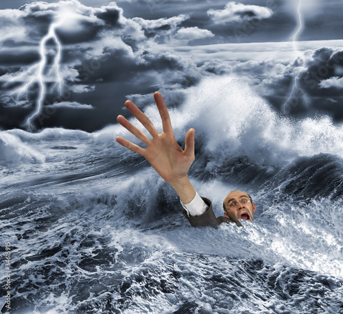 Businessman sinking in dark stormy sea