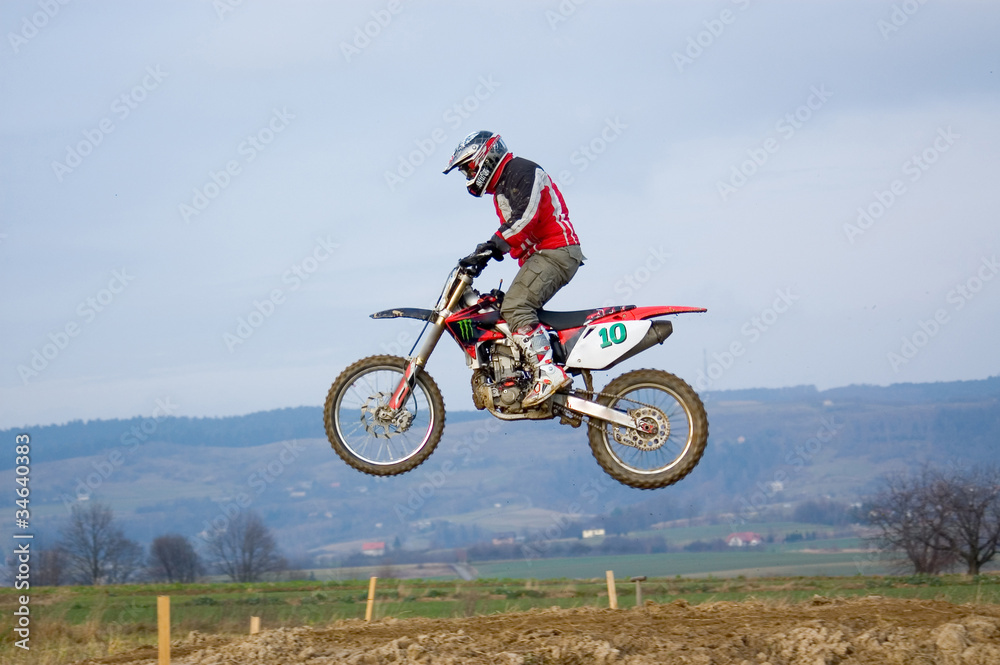 Motokross motocyklista lecący w powietrzu skaczący nad ziemią