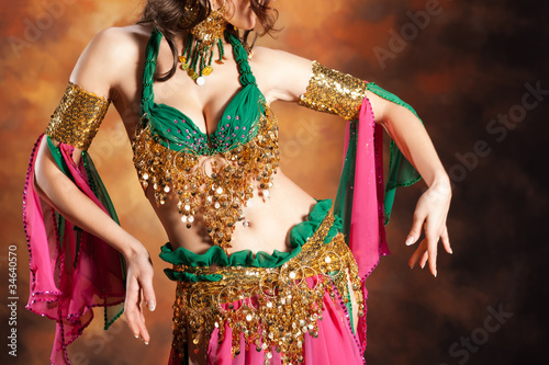 Beautiful exotic belly dancer woman a rot-green costume photo