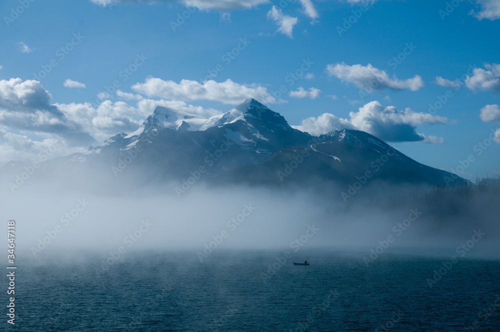 Canoeist in mist on mountain lake