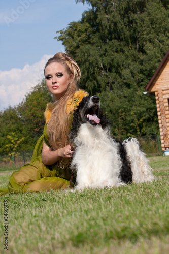 The woman in a beautiful old style dress with borzoi dogs