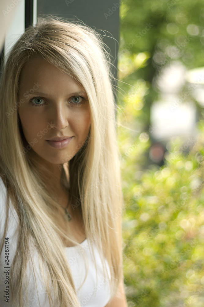 Beautiful young woman with blond hair at the window Beautiful young woman with blond hair at the window