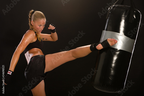 thaiboxerin, Boxsport, Schnelligkeit, Frau schläft mit Fuß auf Boxsack photo