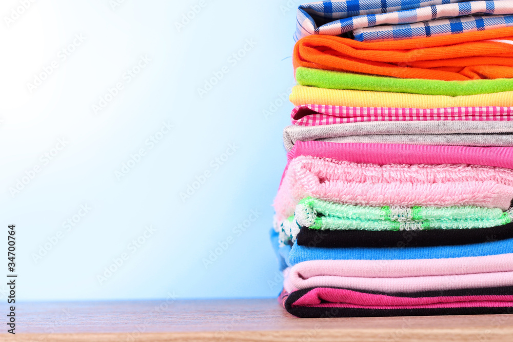 Pile of colorful clothes over blue background Pile of colorful clothes over blue background