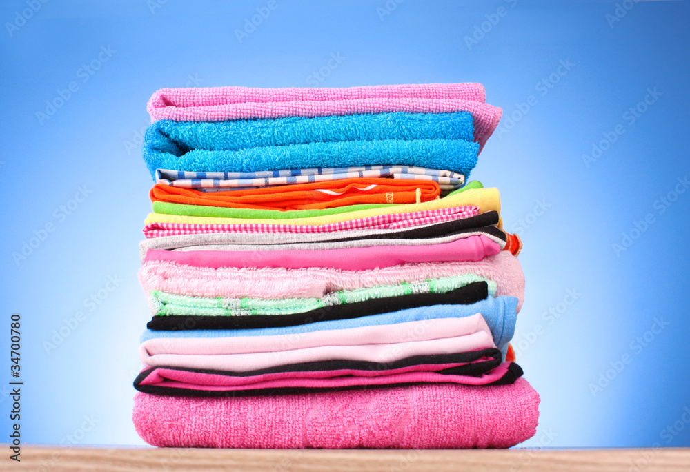 Pile of colorful clothes over blue background Pile of colorful clothes over blue background