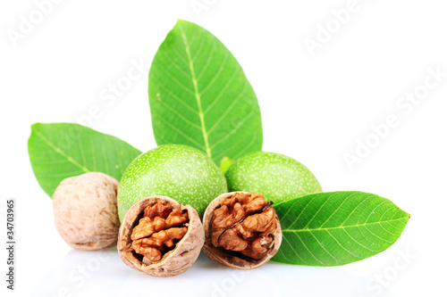 green walnuts and leaves isolated on white